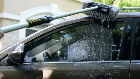 A guy cleaning his Black Car with 12 Flow-Thru Brush Head Soft Bristle Blog Image