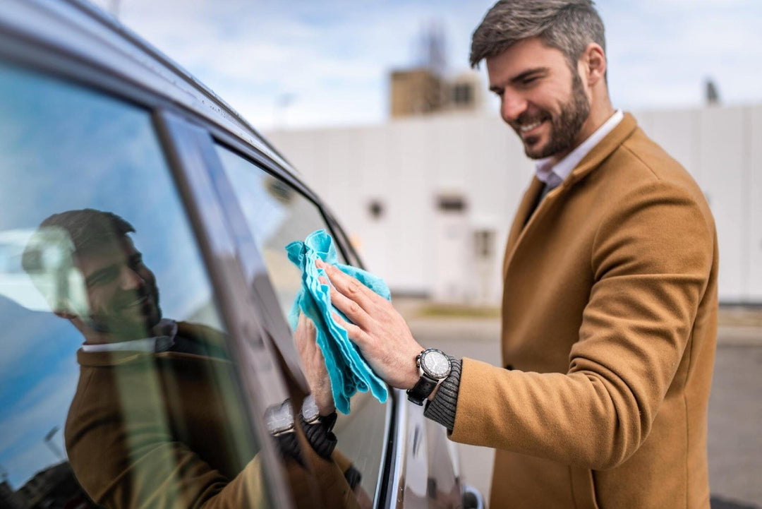 Close-up of mid adult man cleaning his car with a micro fiber towel carcarez blog image