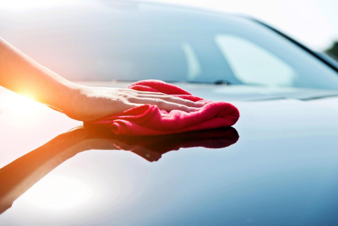 Woman hand drying the vehicle hood with a red towel carcarez blog