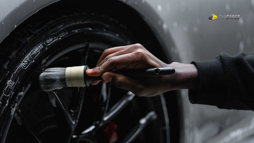 A male hand cleaning car tire with carcarez Boar Hair Interior Detailing Brush