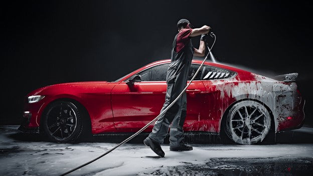 A man washing red mustang with carcarez foam gun for pressure washers or a car detailing pump sprayer product