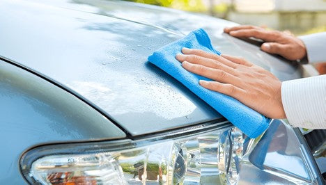 Close-up of a Royal Coral Fleece Microfiber Towel absorbing water from a car surface, demonstrating its high-density 880GSM weave for quick drying.