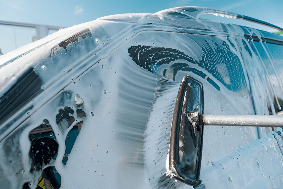 Close-up of a car being washed in outdoor setting with soapy foam, as a car being cleaned by a CarCarez 15 Automotive Multi-Level Nog Hair Wash brush scrubs the surface. 