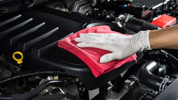 Person cleaning car engine with Carcarez Microfiber towel