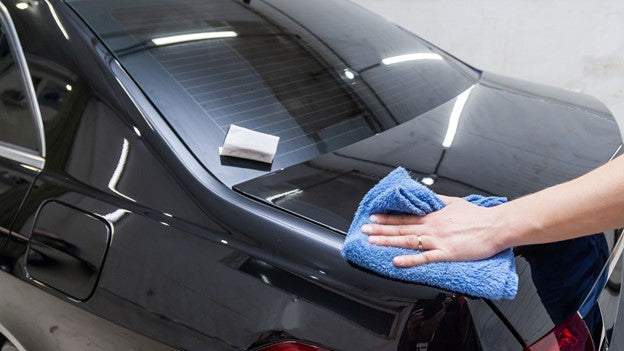 Person cleaning car with CarCarez Microfiber towel