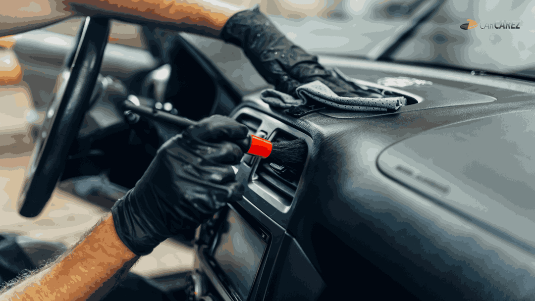 Person in wearing black gloves cleaning car dashboard carcarez brush and microfiber towel. Blog Image