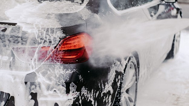 Person washing car with CarCarez Foam canon