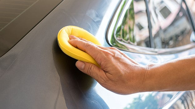 Person waxing car with CarCarez Product