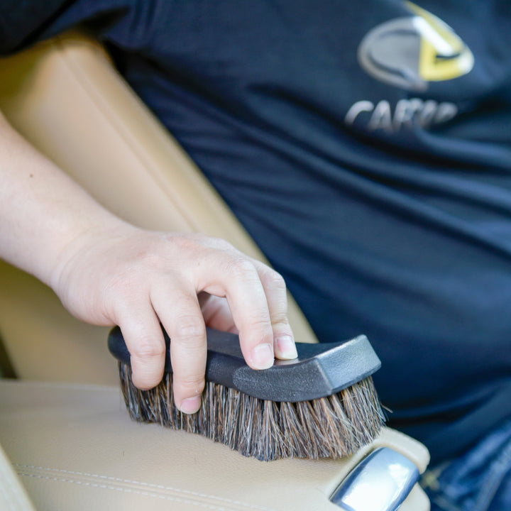 A man in blue shirt cleaing car